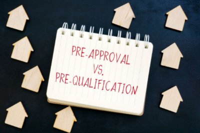 A notepad with "Pre-Approval Vs. Pre-Qualification" written on it surrounded by several arrows pointing up.
